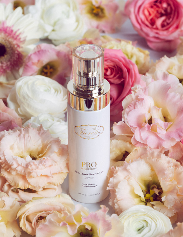 Floralla Pro Moisturizing Rejuvenation Lotion, in white bottle with gold accents, surrounded by pink and white roses.