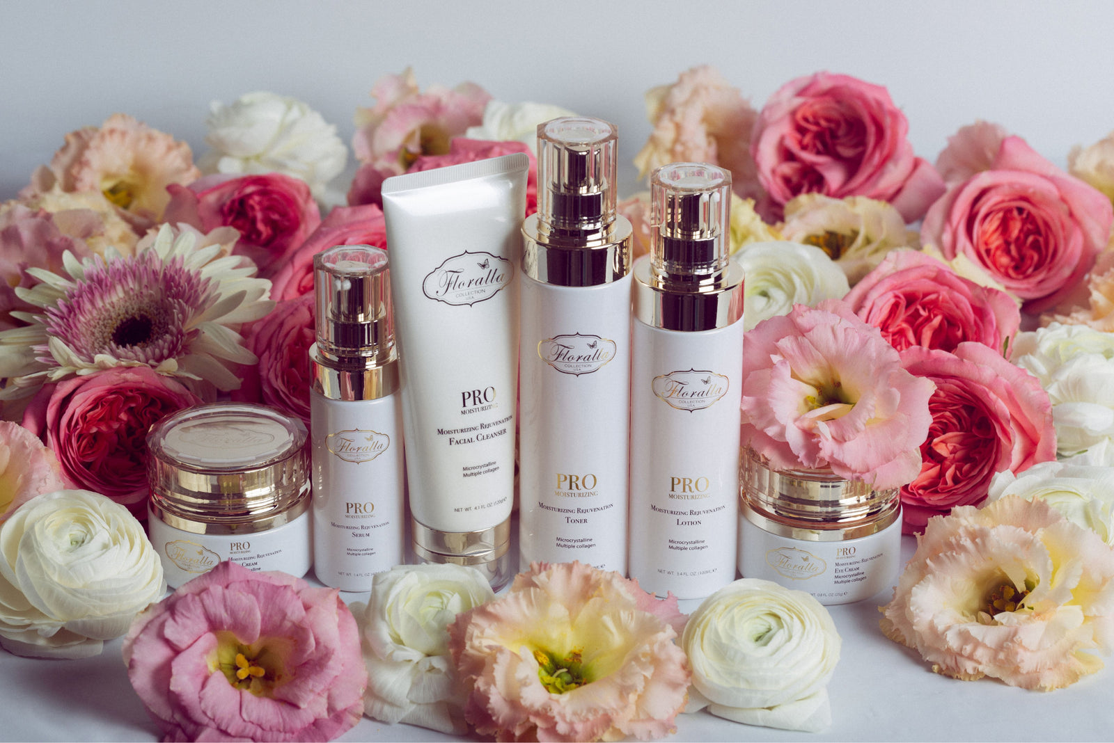 Floralla PRO Skincare Collection: A set of luxury skincare products, including a toner, serum, moisturizer, and eye cream, displayed on a bed of roses.