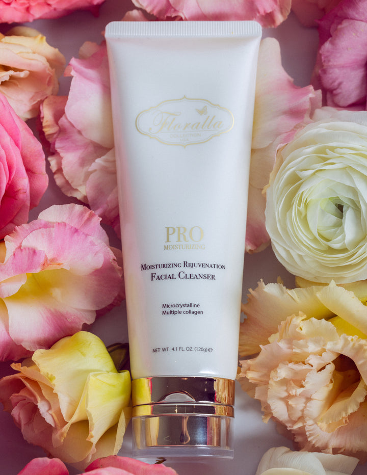 Floralla Pro Moisturizing Rejuvenating Facial Cleanser, in white tube with pink floral accents, surrounded by pink and white roses.